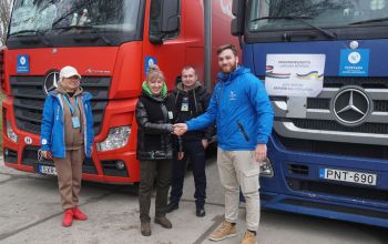 Szatmári Barnabás (jobb oldalon), az Ökumenikus Segélyszervezet munkatársa adományt ad át Ukrajnában