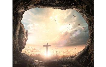 Empty tomb stone with cross on meadow sunrise_foto_Boonyachoat_GettyImages_Canva