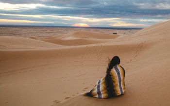 sivatagban ülő asszony